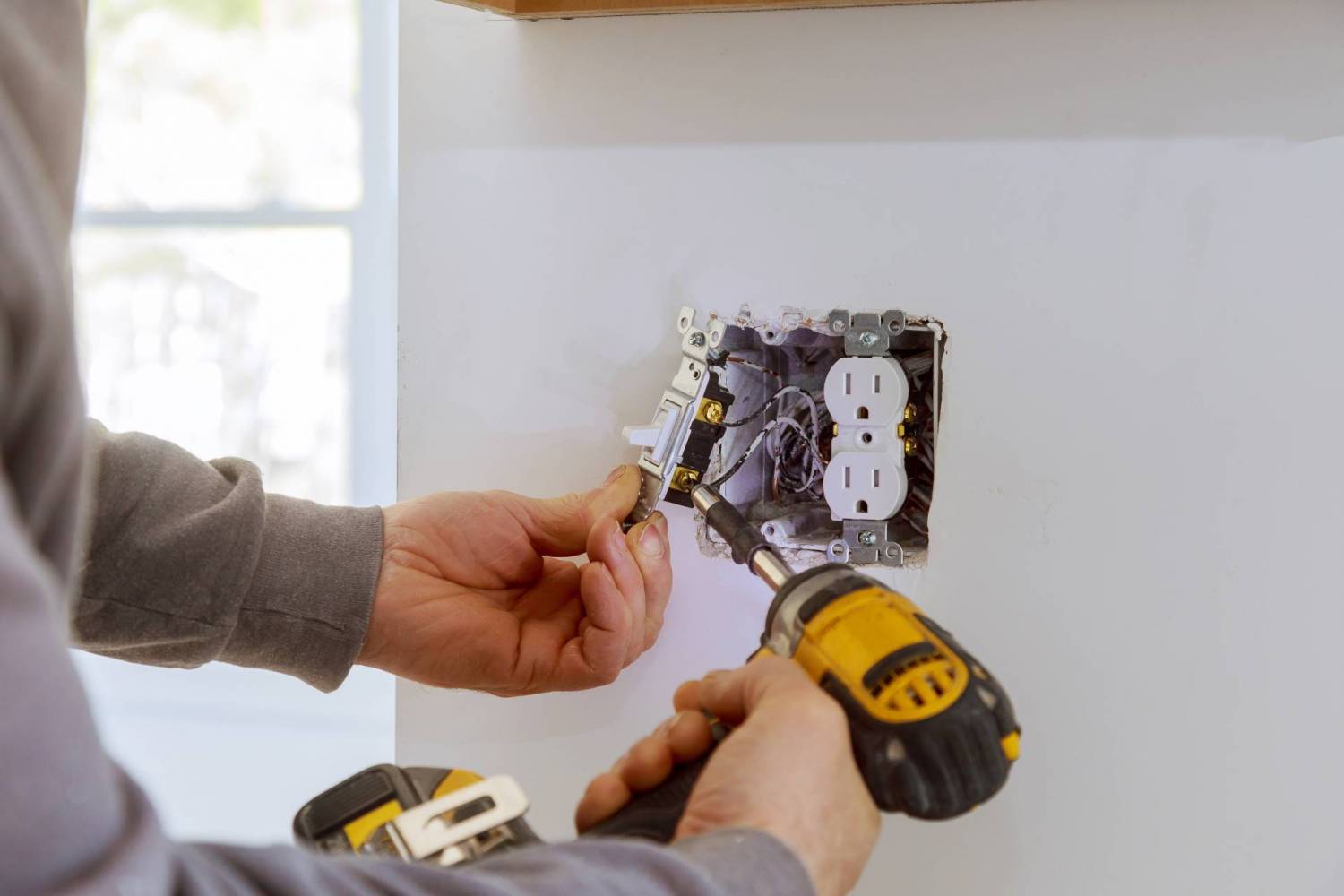 Homeowner inspecting a circuit breaker panel for common electrical problems.