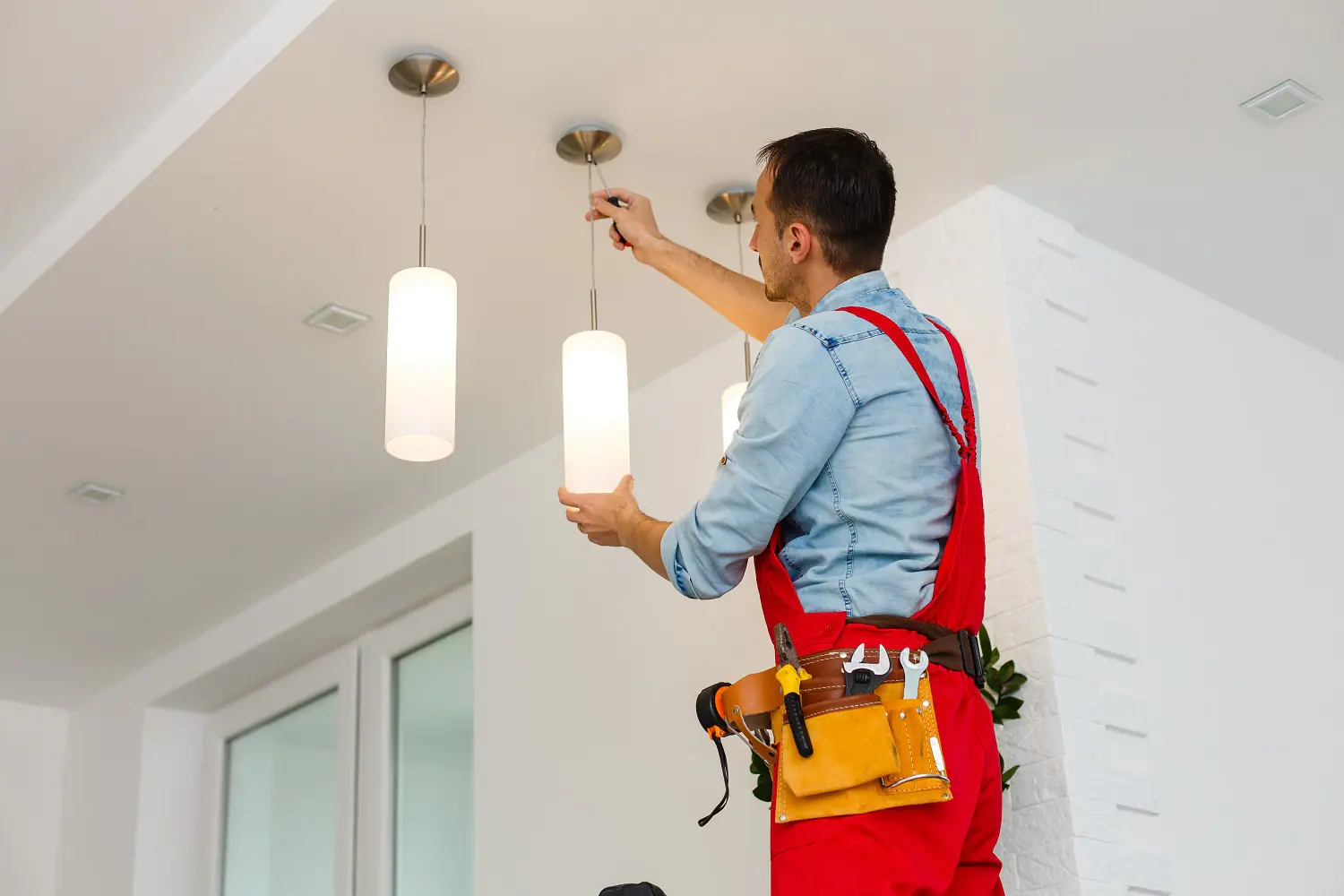 A homeowner safely replacing a light bulb in a well-lit room.