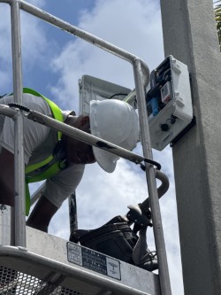 Licensed electrician testing electrical panel with professional equipment in Florida home